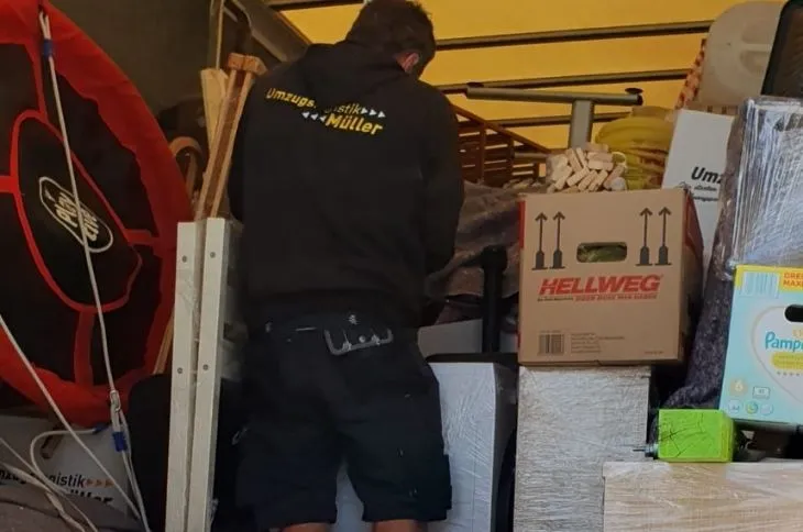 umzugshelfer sichert hausrat und kartons im umzugswagen
